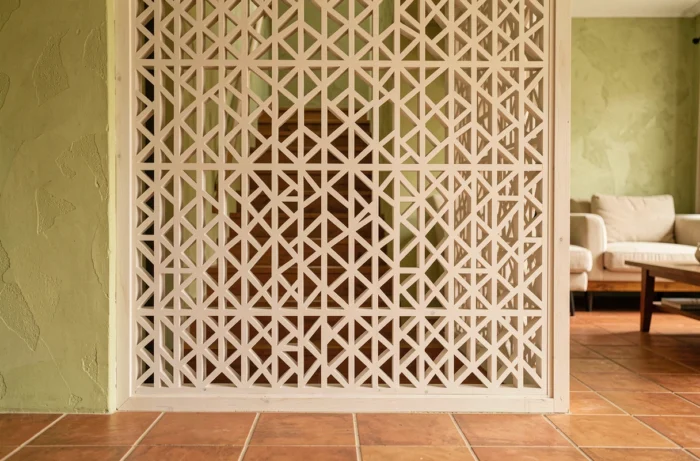 Claustra en bois sculpté aux motifs géométriques servant de séparation décorative en cage d'escalier