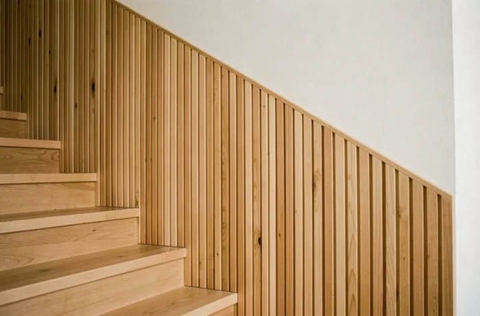 Soubassement en tasseaux de bois verticaux le long d'un mur d'escalier intérieur contemporain